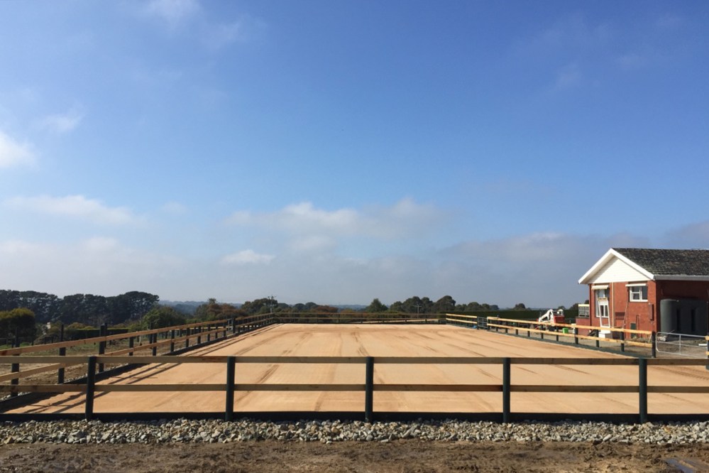 Sand horse arena with fence and rock edging